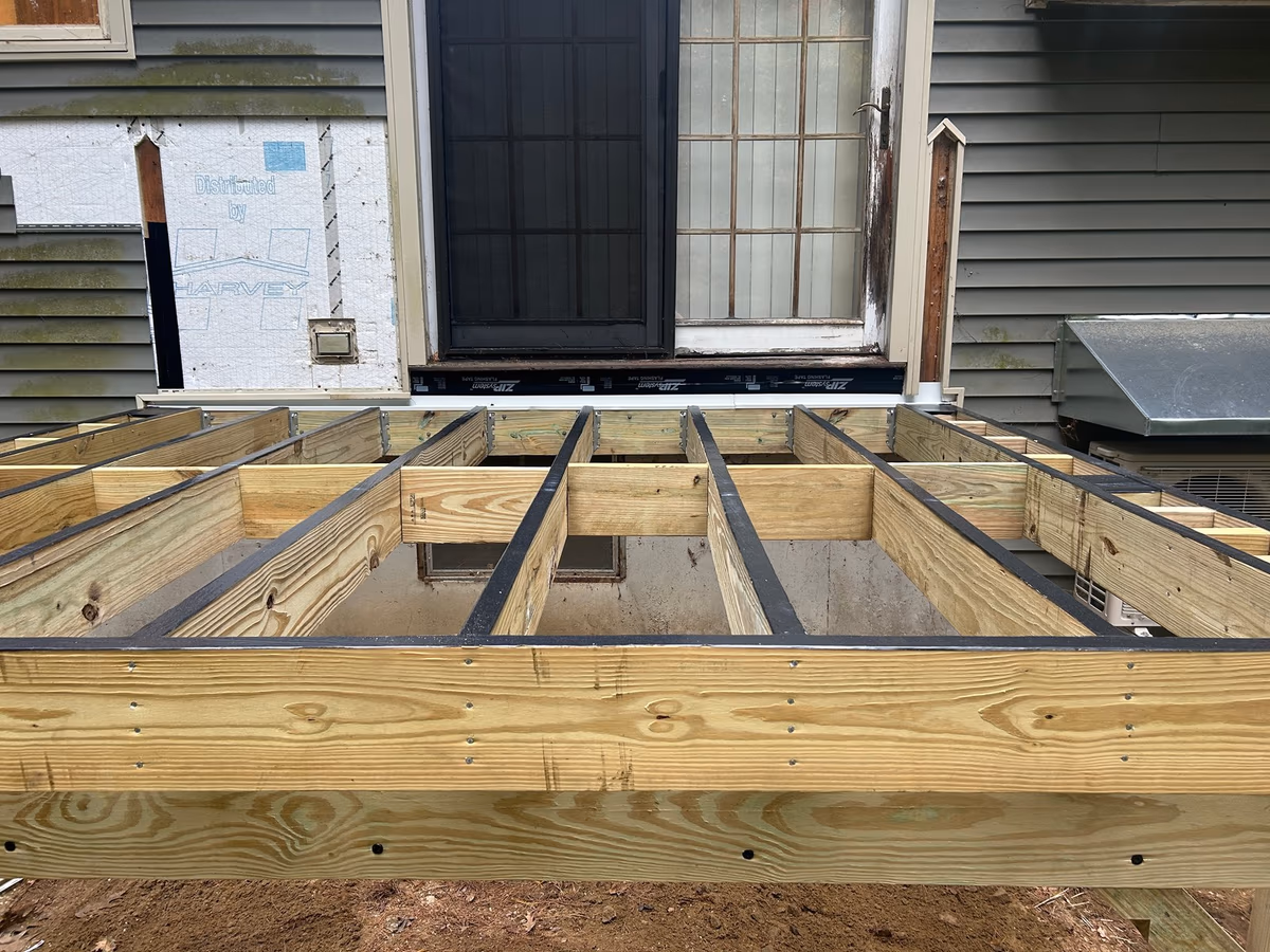 Deck joists framed and hung off the ledger before Trex decking was fastened down, Milton VT