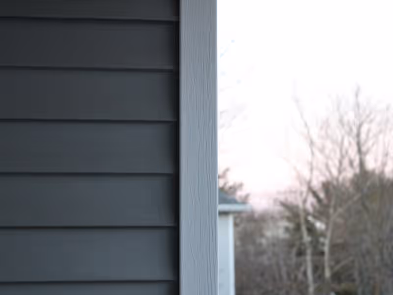 Charcoal lap siding meeting a light gray corner board on a newly sided Vermont home by Empirical Renovations