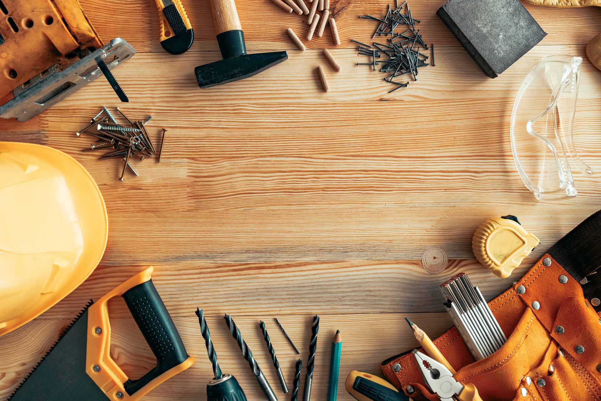 Miscellaneous construction tools scattered on a wooden bench