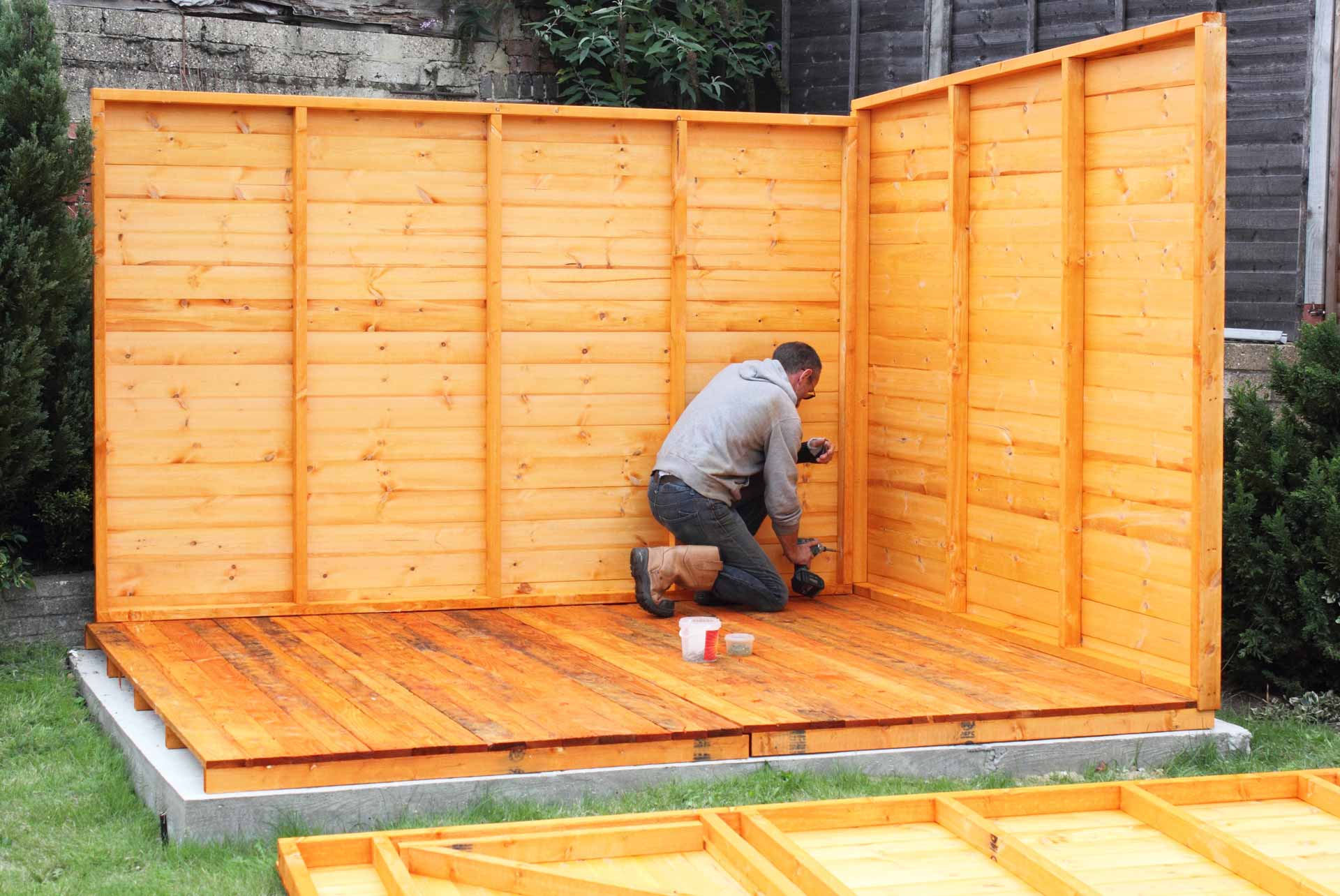 Man building wooden shed